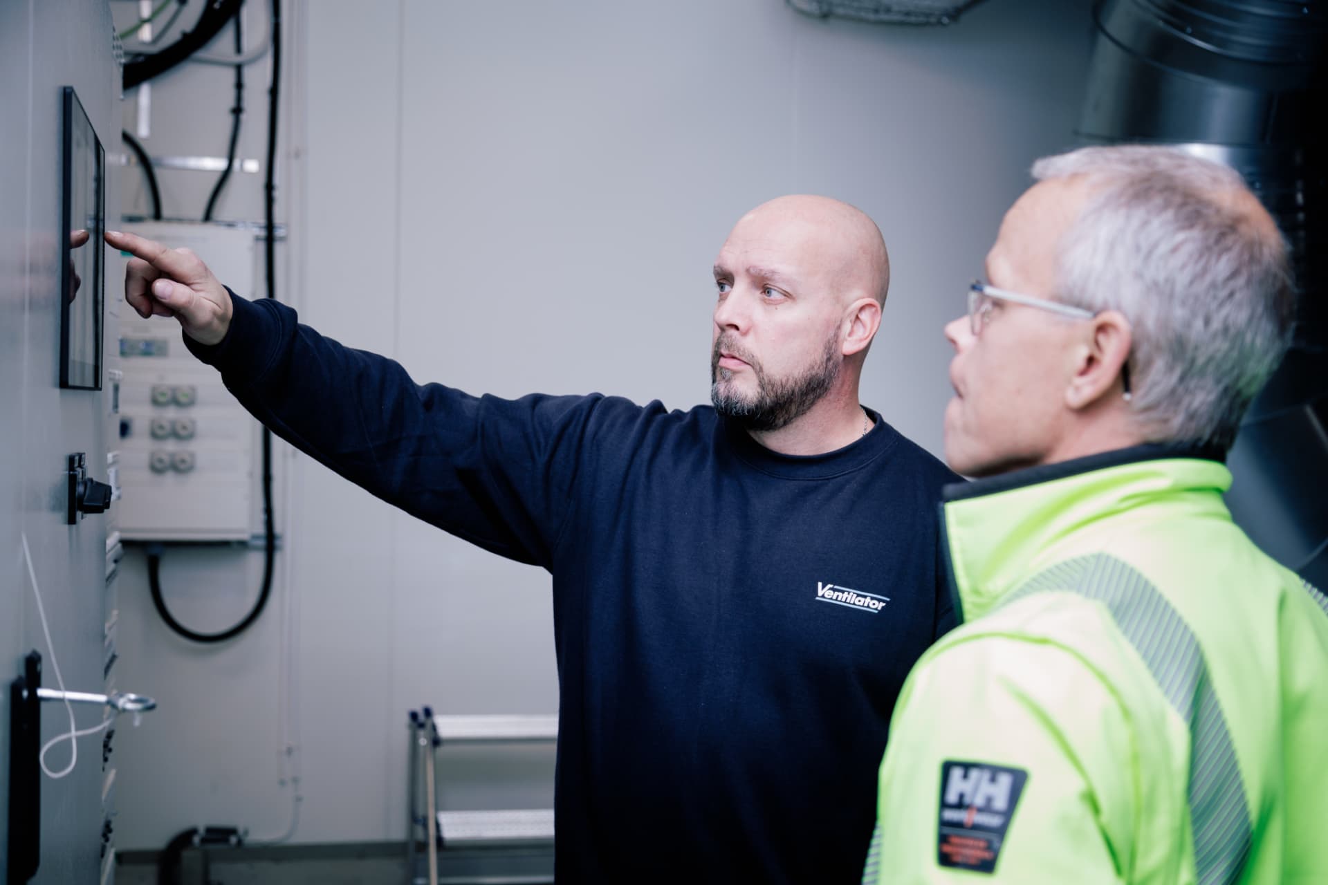 Servicetekniker från Ventilator går igenom styrsystemet i ett fläktrum